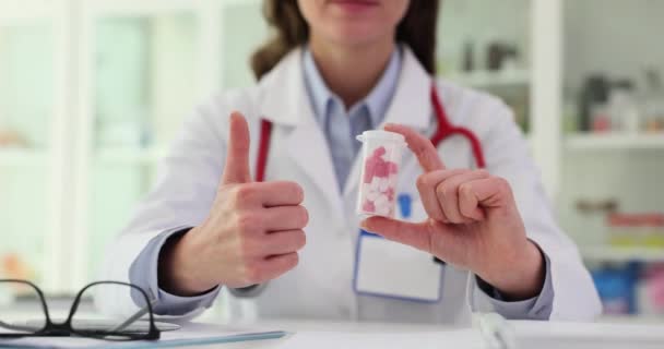 薬剤師は錠剤の容器を保持し 親指を示しています 質の薬および承認される — ストック動画