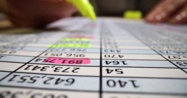 Kağıt işleri ve el işleri. Finansal sayısal verilerin basılı olduğu kağıt üzerinde pembe ve sarı işaretli notlar. Muhasebe kavramı