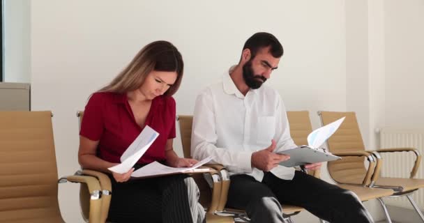 ビジネス女性と男性は オフィスロビーで会合を待っている間 投資家との交渉や文書を読む準備をしています ビジネスロビーでのインタビュー準備 — ストック動画