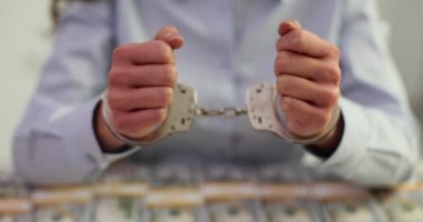 Ahlaksız memurun elleri kelepçeli ve Amerikan doları. Dolandırıcılık ve iş yerinde siyasetçinin tutuklanması