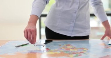 Dünya haritasında kadın eli uçak tutuyor. Uçak biletleri ve ikramiye programında indirimler ve promosyonlar