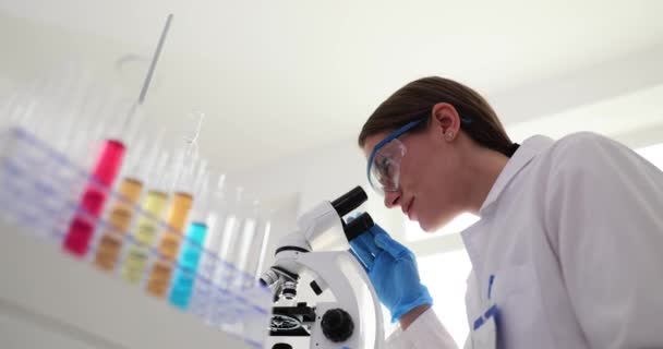 Vrouwelijke Wetenschapper Kijkt Door Microscoop Vindt Nieuwe Stof Kleurrijke Vloeistof — Stockvideo