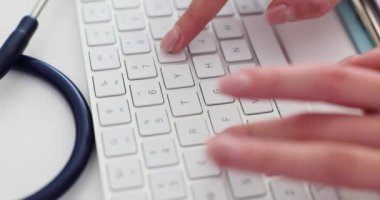 Doktor elleri beyaz bilgisayar klavyesinde yazıyor. Teletıp ve tıbbi teknolojiler