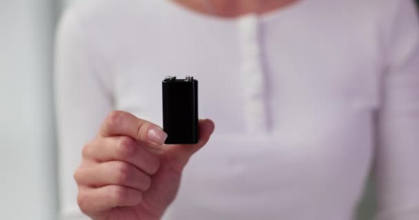 女性の手と親指でブラックバッテリー王冠 良質のコロナ電池および販売人の推薦 — ストック動画