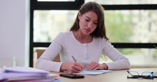 ビジネス女性は ペンでメモ帳に書き込み オフィスの財務諸表を計算します 美しい女の子は未来のための考えと計画を書く — ストック動画