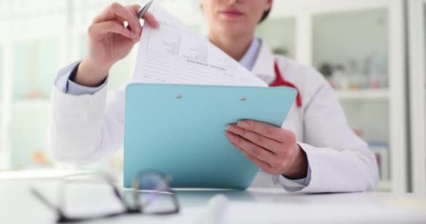 Γενικός Ιατρός Εξετάζει Ιατρικά Έγγραφα Κατά Διάρκεια Της Διαβούλευσης Στην — Αρχείο Βίντεο