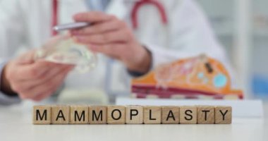 Doktorun elinde yeni silikon göğüs implantı ve kelime memecilasti var. Estetik ameliyat ve göğüs büyütme