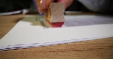 Reddedilen belgelerin yazılı metninde reddedilen damgalı kişinin el damgası form ve sözleşme masasında. İş kadını iş projesini reddeden pulu imzaladı