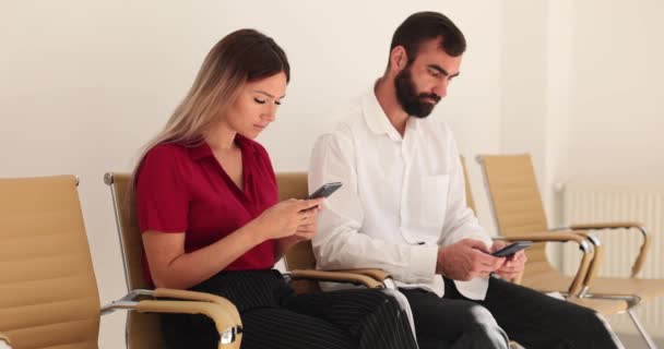 Två Personer Sitter Rad Med Smartphones Och Väntar Intervju Personalresurser — Stockvideo