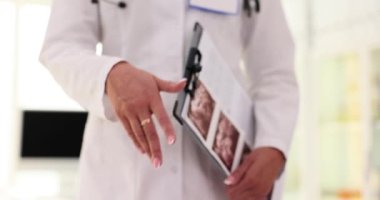 Doktor elleri misafirperver davranır ve hastayı nazikçe muayenehaneye davet eder. Doktor elinde ultrason sonuçlarıyla tıbbi belgeler tutuyor.