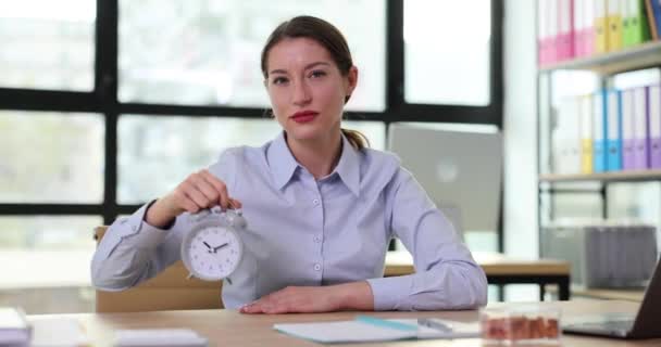 不満の女性ボスは 遅くについて企業の従業員を暗示するヴィンテージの目覚まし時計に指を指します 執行人からの時間と罰の管理が適切でない — ストック動画