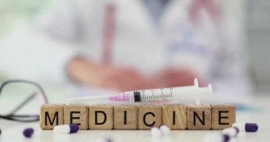 Şırınganın yanına, hastanede çalışan doktorlara karşı ahşap bloklardan yapılmış ilaçlar serpiştirilmiş. Hastalıkları tedavi etme ve insanlara yardım etme bilimi