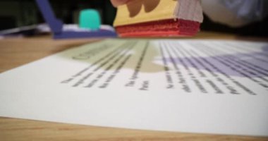 Kadın sekreter, yatırımcıyla olan anlaşmasının reddedildiği belgeye kırmızı mühür basıyor. Çalışma akışı ve anlaşma belgesi ofiste