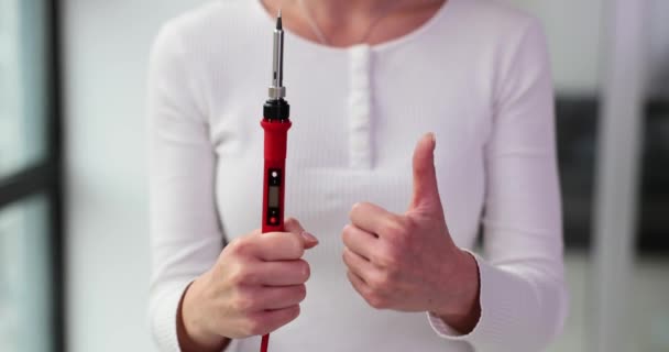 여성은 기술의 승인을 엄지손가락을 보여주는 배터리 테스트 장치를 보유하고 있습니다 — 비디오