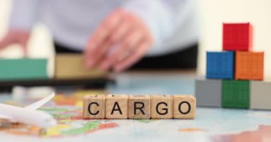 Sözcük Kargosu, tahta küplerden üretilmiş. Elinde konteynır modelleri olan bir kadına karşı. Büyük ölçekli ürünlerin farklı ülkelere taşınması