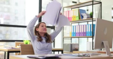 Mutlu kadın başarılı bir işlemi tamamladıktan sonra belgeleri dağıtıyor. Yılların sonu projesi. Şirket çalışanlarının pozitif duyguları ağır çekimde