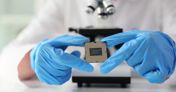 橡胶手套工程师在实验室里拿着芯片形式的计算机部件来对抗现代显微镜 专业人员进行的实验 — 图库视频影像