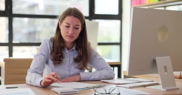 女会计师使用计算器计算支出 并将数据输入纸面表格 对轻型办公室工作场所分配的任务采取勤奋的做法 — 图库视频影像