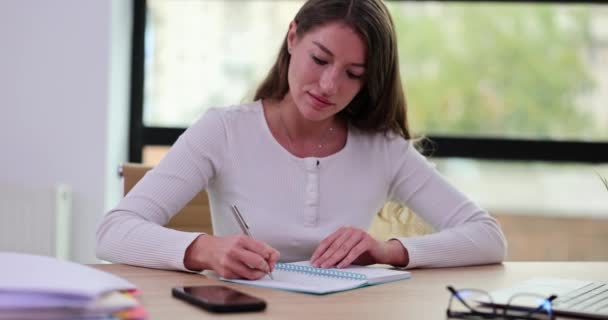 Konzentrierte Frau Die Tisch Auf Notizblock Schreibt Ausbildung Und Businessplanung — Stockvideo