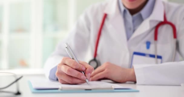 医生或护士写下病人的资料 治疗师在诊所写下附有医疗文件的处方 — 图库视频影像