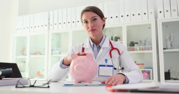女性医師が病院でブタバンクとストロークを抱えています 医療保険 医療費について — ストック動画