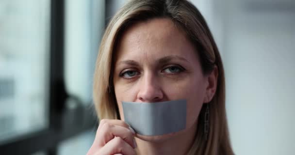 悲しい女性はダクトテープを顔から取り除きます 家庭内暴力と社会問題 — ストック動画