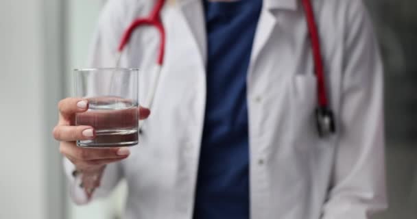 医生用大拇指托着杯子喝水的样子 医生建议早上喝干净的水 — 图库视频影像