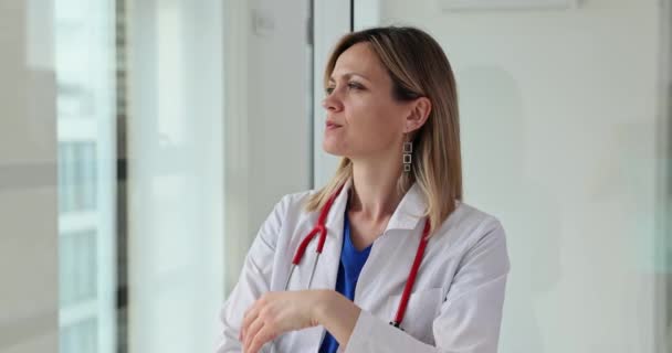 Μια Σκεπτική Γυναίκα Γιατρός Κοιτάει Έξω Από Παράθυρο Πρόβλημα Του — Αρχείο Βίντεο