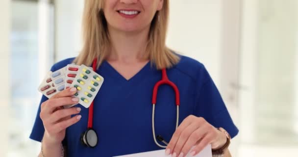 女性医師は さまざまなピルブリストと空白の形のパッケージを手で保持しています 医薬品の処方箋について — ストック動画