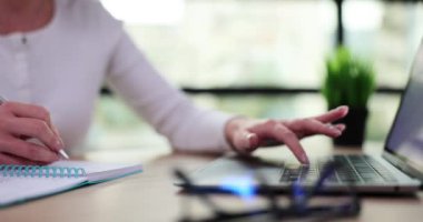 İş kadını not defterine yazar ve ofiste dizüstü bilgisayar kullanır. Uzaktan eğitim ve İnternet 'te bilgi arama