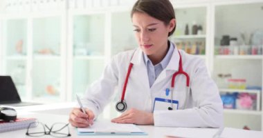 Kadın doktor hasta için tedavi planı yazıyor. Tıp terapisti klinikte belgeler hazırlıyor.