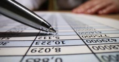 Kadın finansal rapor verileriyle çalışıyor. Muhasebe raporu inceleniyor