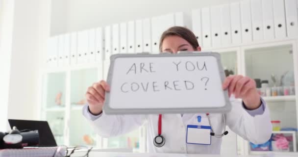 医生带着卡片宣布你是否参加了自愿保险 提供医疗服务 — 图库视频影像