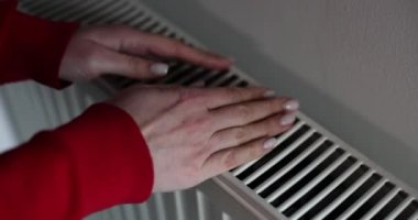 Isıtıcı soğuk radyatörleri ve kadın ellerini kapatıyorum. Araçlar ve eller sıcak radyatör