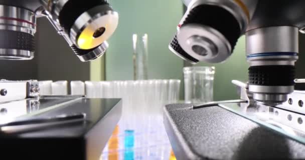 テーブルのテスト管の着色された液体が付いている多くの顕微鏡およびテスト管が付いている現代医学の研究所 科学実験のためのラボ — ストック動画