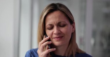 Üzgün genç bir kadın telefonda konuşuyor ve kötü haberler alıyor. Üzüntü ve stres iletişimi