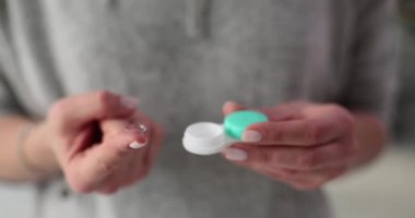 Kadın ellerinde konteynır olan yumuşak kontakt lens. Oftalmoloji ve kontakt lensler