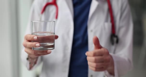 水と親指を握っている医師 栄養士および食事療法のレジメンからの推薦 — ストック動画