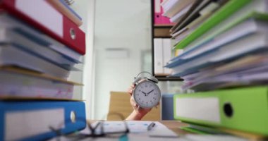 Masadaki büyük kağıt ve klasörlerden gelen çalar saatle. Fazla mesai belgeleri ve son teslim tarihi.