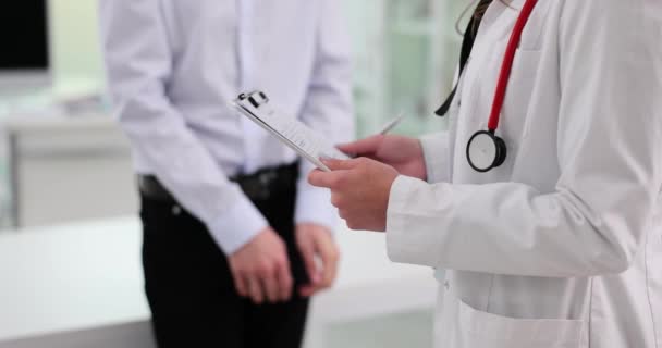 Dokter Urologis Menulis Diagnosis Medis Dengan Pasien Rumah Sakit Laki — Stok Video
