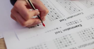 Öğretmen sınav sınavında B sınıfı kırmızı kalemle 4K 'lık filmi yavaş çekimde kapatıyor. Eğitim kavramı