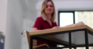 İş kadını çalışma masasında oturuyor ve kırışık belgeyi çöp kutusuna atıyor. Evrak işlerindeki hatalar