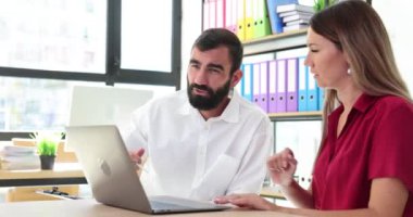 İş ortakları internetteki dizüstü bilgisayar 4K filminde bilgi tartışıyor. Takım çalışması konsepti