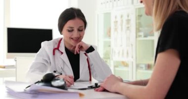 Doctor writing down patient complaints in medical history at clinic appointment 4k movie slow motion. Maintaining medical records concept