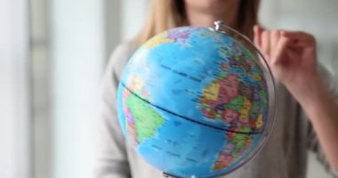 Woman travel agent spinning globe closeup 4k movie slow motion. Travel abroad concept