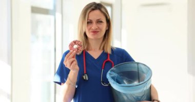 Doctor nutritionist throwing sweet donut into trash bin 4k movie slow motion. Healthy food concept