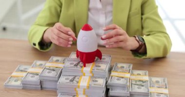 Rocket taking off from stack of money dollar bills closeup 4k movie slow motion. Startup and ideas in business development concept