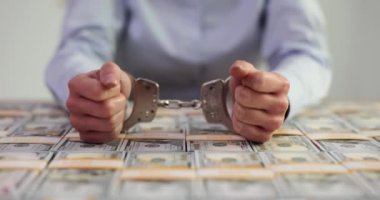 Elleri kelepçeli yozlaşmış kadın yöneticinin elleri ve Amerikan doları. Dolandırıcılık ve dolandırıcılık.