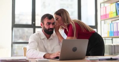 Kadın yönetici ofis arkadaşına gizli şeyler fısıldıyor. İşçiler ofiste dedikodu yapıyor.