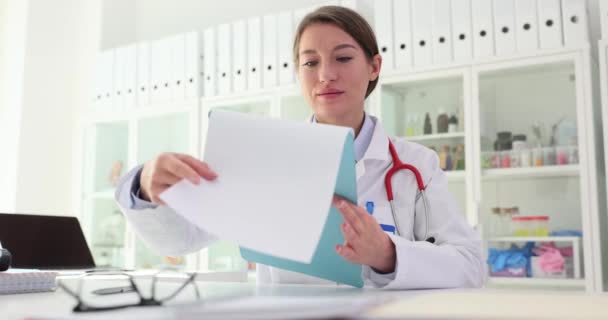 Жінка Лікар Офісі Вивчає Документи Після Операції Сидячи Столом Медична — стокове відео